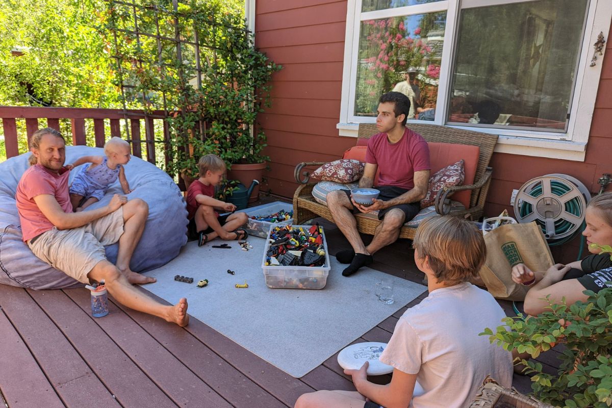 Family hanging out on the deck and playing with their children