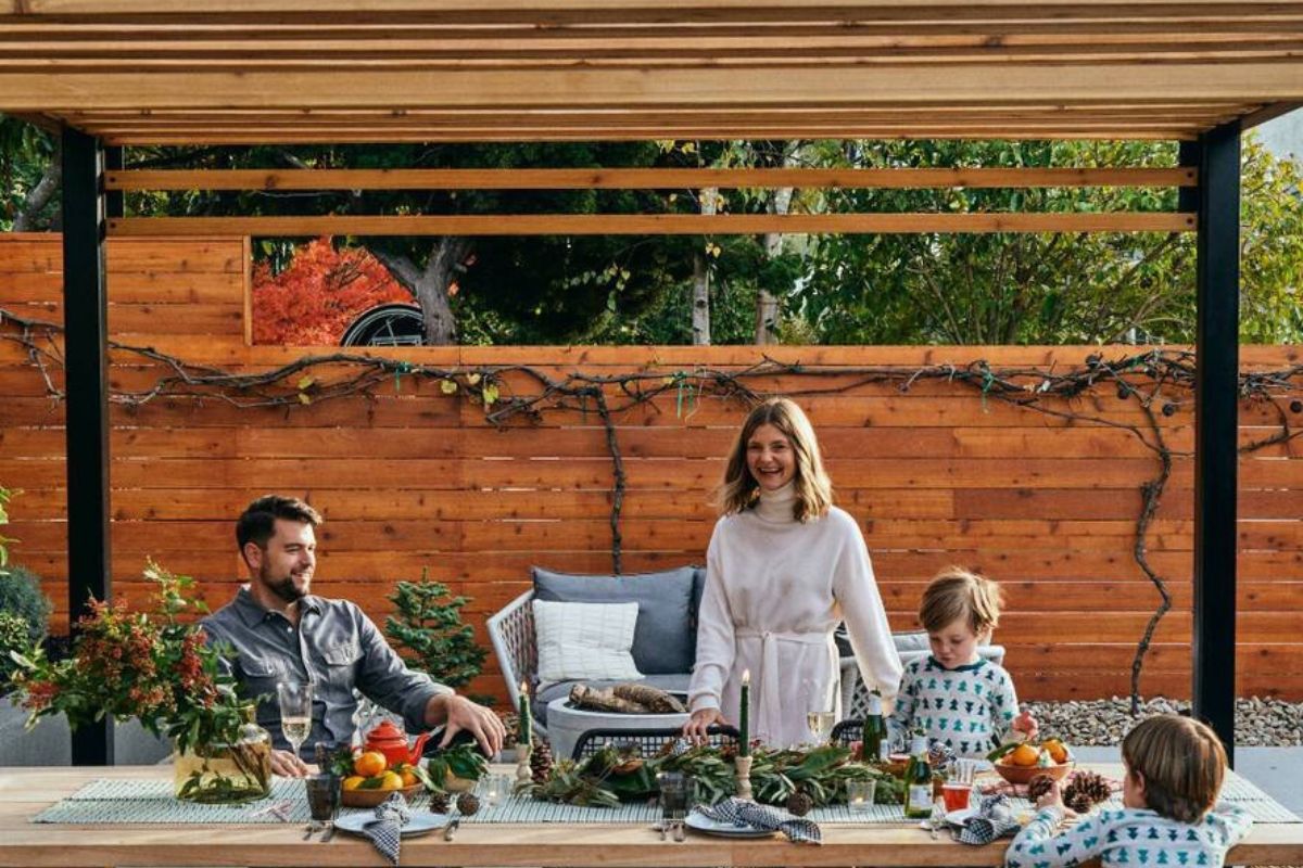 happy couple spending time with their children under pergola on weekend