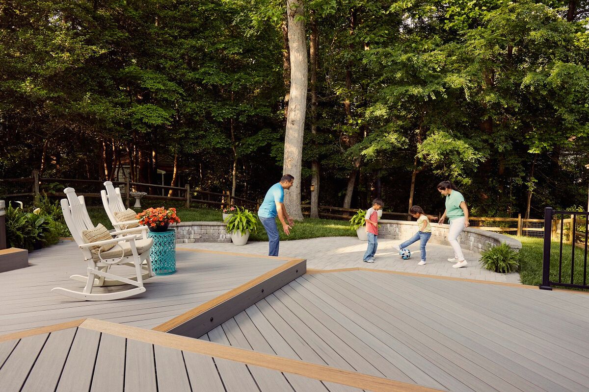 married couple playing with their children on backyard deck of the house