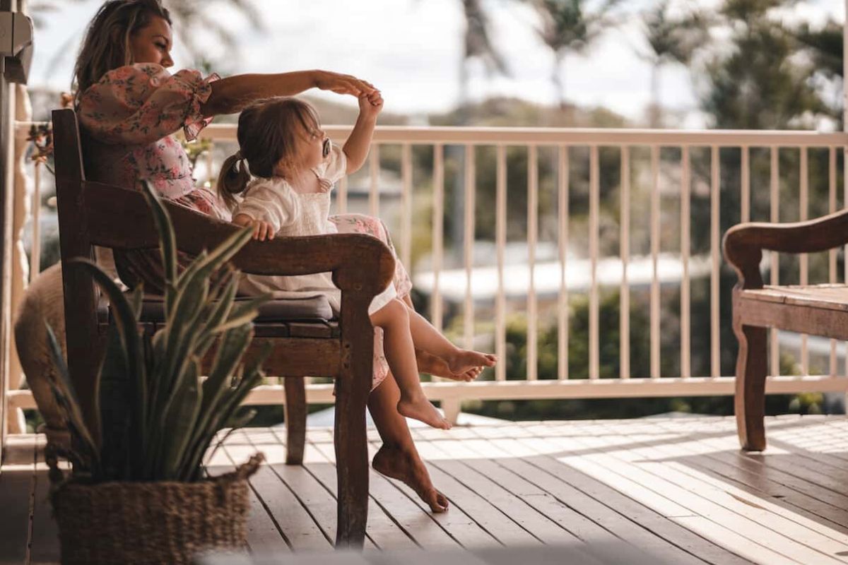 mother and daughter sitting on the deck of the house