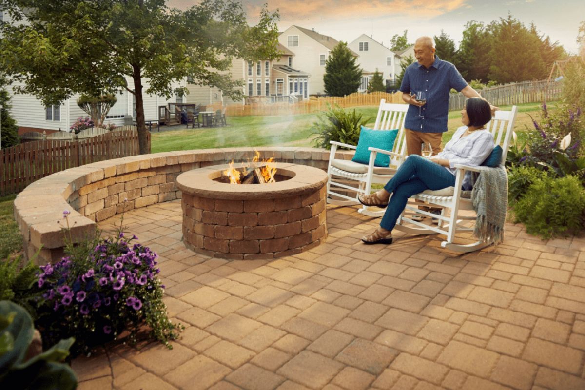 senior couple drinking wine in hardscape patio of their house on weekend