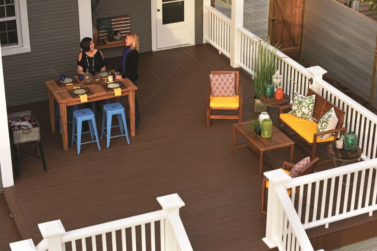 two sister laughing and drinking wine on deck of the house